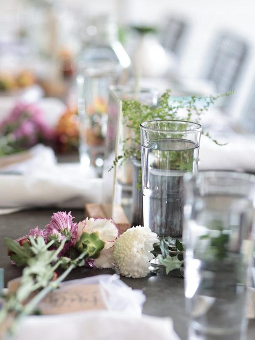 A long table set for the room, with fresh flowers and a place card at every seat.