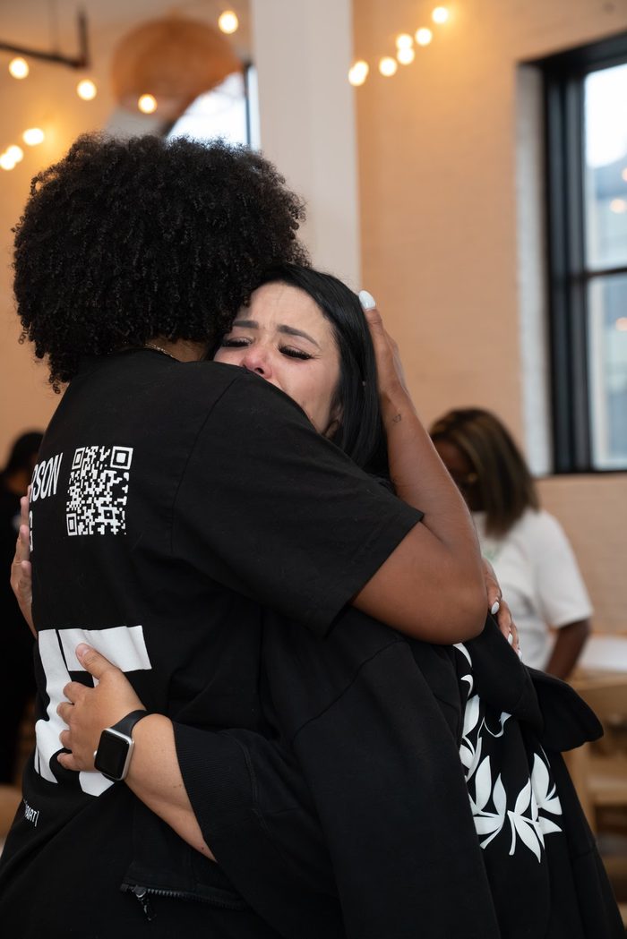 Two women holding each other, one of them in tears, at the end of a gathering.
