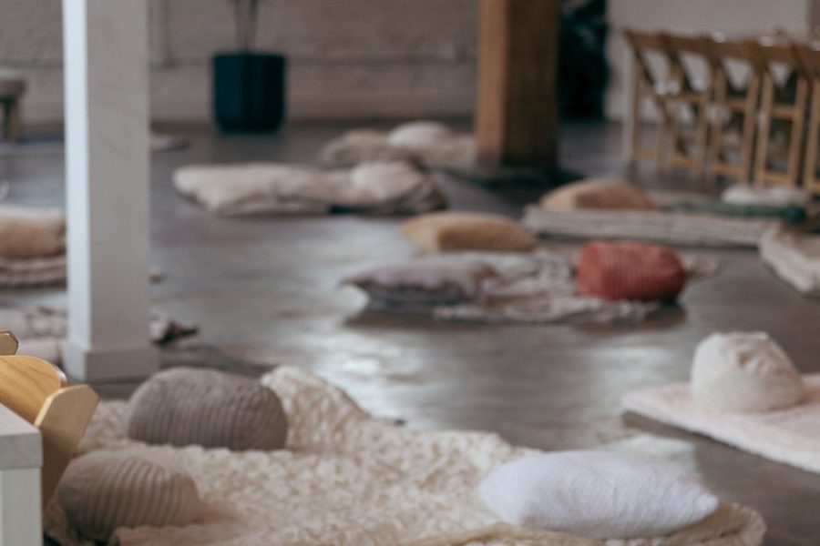 The room before anyone arrives: blankets, floor cushions and low seating laid out across the floor.